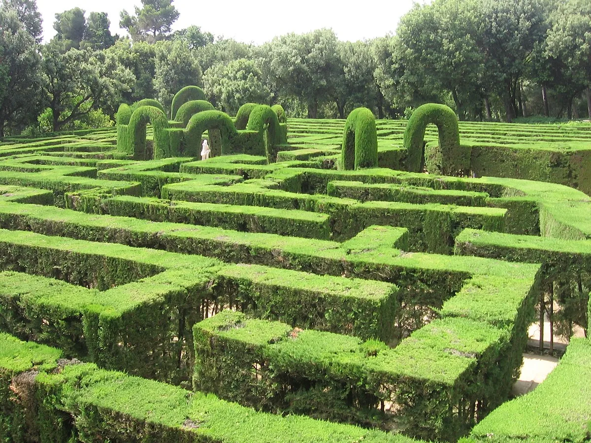 Het neoklassieke labyrint van het Parc del Laberint d'Horta in Barcelona vanuit de lucht gezien, met groene hagen en bezoekers